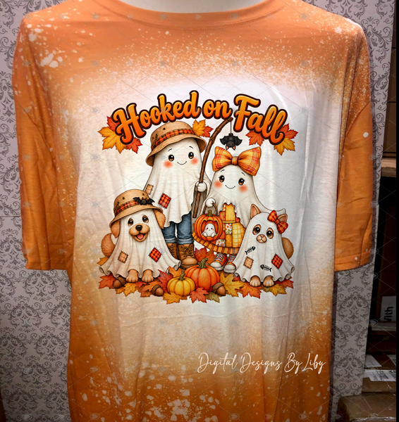 Tie dyed orange T-shirt featuring Hooked on Fall lettering above two ghost children, a ghost dog and cat, pumpkins, and autumn leaves.